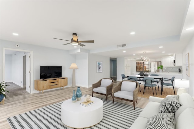 living room with ceiling fan and light hardwood / wood-style floors