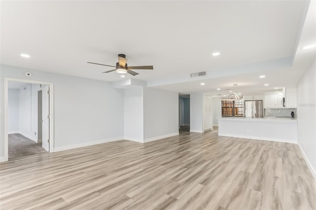 unfurnished living room featuring ceiling fan and light hardwood / wood-style flooring