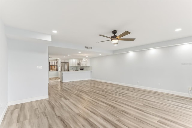 unfurnished living room featuring ceiling fan and light wood-type flooring