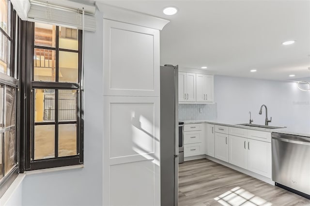 kitchen with sink, white cabinetry, stainless steel dishwasher, and tasteful backsplash