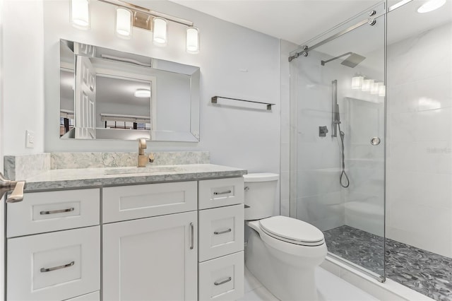 bathroom with an enclosed shower, vanity, and toilet