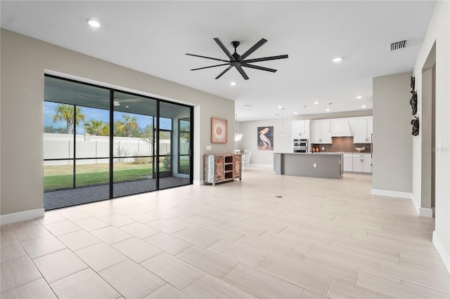 unfurnished living room with ceiling fan