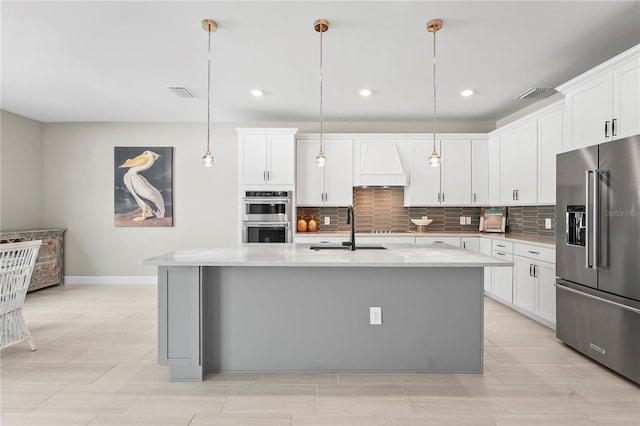 kitchen featuring white cabinetry, appliances with stainless steel finishes, sink, and a center island with sink