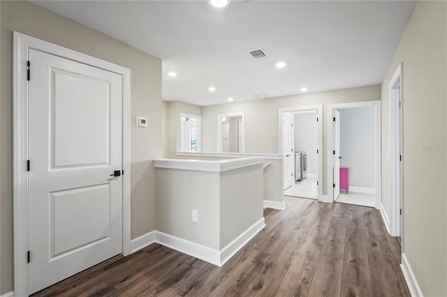 hall with hardwood / wood-style flooring and washer / dryer