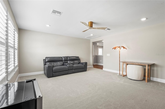 carpeted living room with ceiling fan