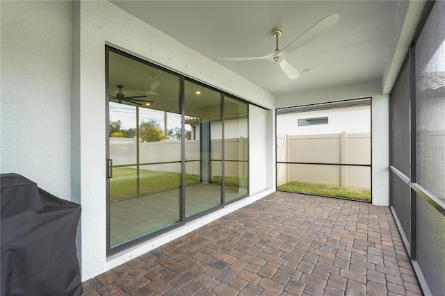 unfurnished sunroom featuring ceiling fan