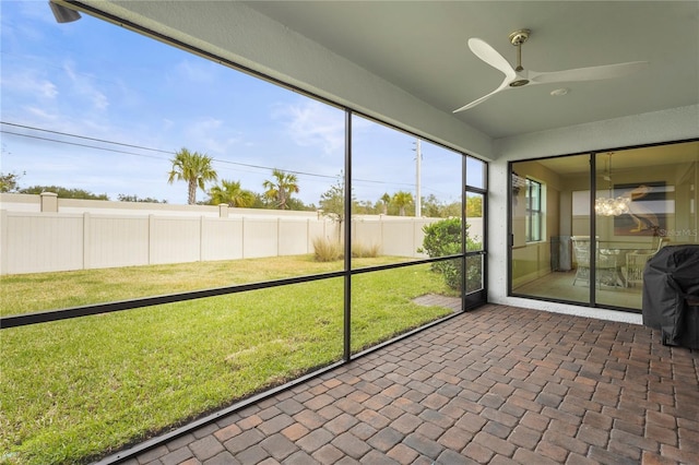 unfurnished sunroom featuring ceiling fan