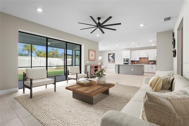 living area featuring baseboards, a ceiling fan, visible vents, and recessed lighting