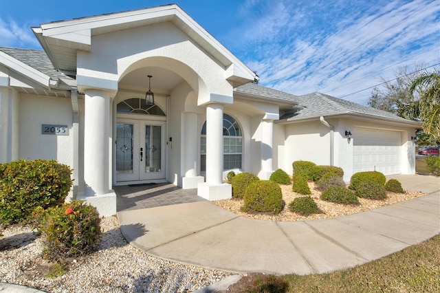 view of exterior entry with french doors and a garage