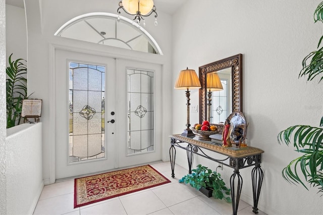 entryway featuring light tile patterned flooring, a healthy amount of sunlight, and french doors