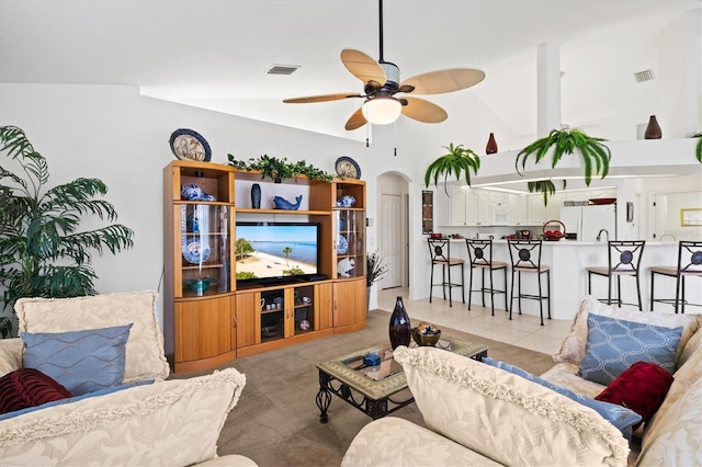 tiled living room featuring ceiling fan and high vaulted ceiling