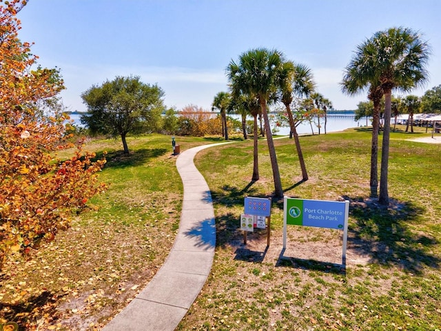 view of home's community with a water view and a lawn