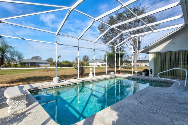 view of swimming pool featuring glass enclosure, a patio area, and a lawn