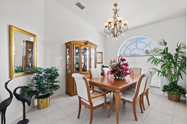 tiled dining area with high vaulted ceiling and a chandelier