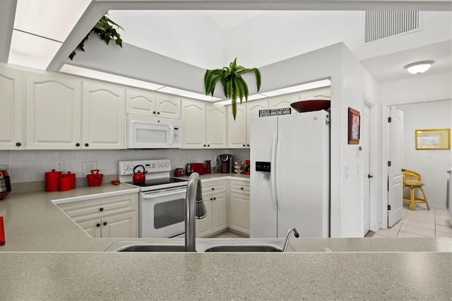 kitchen featuring white cabinetry, white appliances, and tasteful backsplash