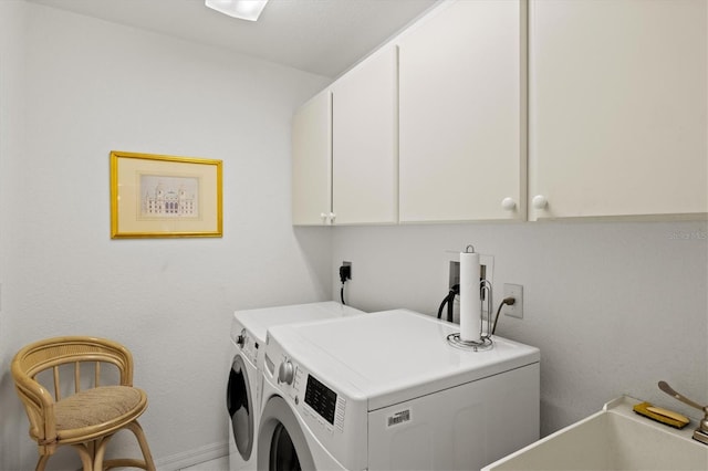 clothes washing area featuring independent washer and dryer and cabinets