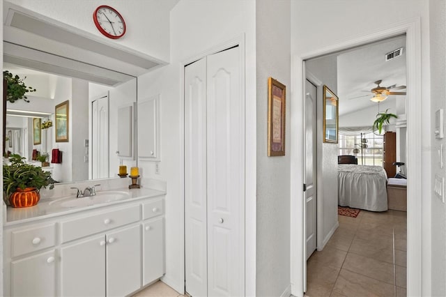 bathroom with tile patterned flooring, vanity, lofted ceiling, and ceiling fan