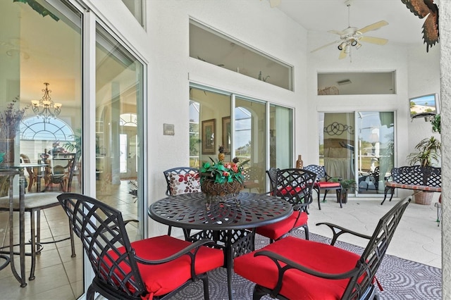 exterior space featuring ceiling fan with notable chandelier