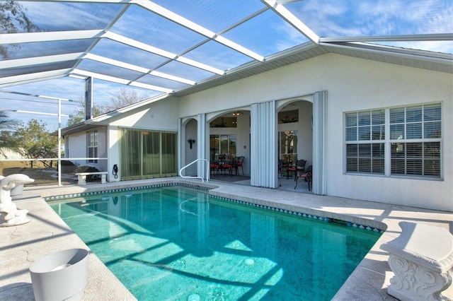 view of pool with a patio area and glass enclosure