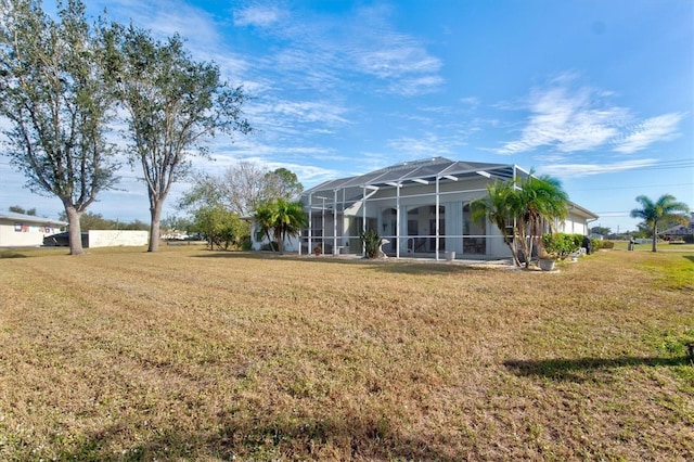 rear view of property featuring a yard and a lanai