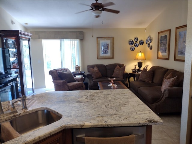 living room with light tile patterned floors, ceiling fan, and sink