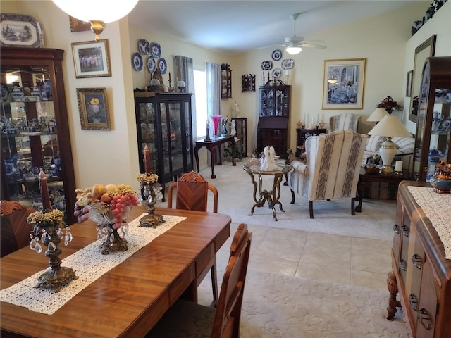 dining area with ceiling fan and light carpet