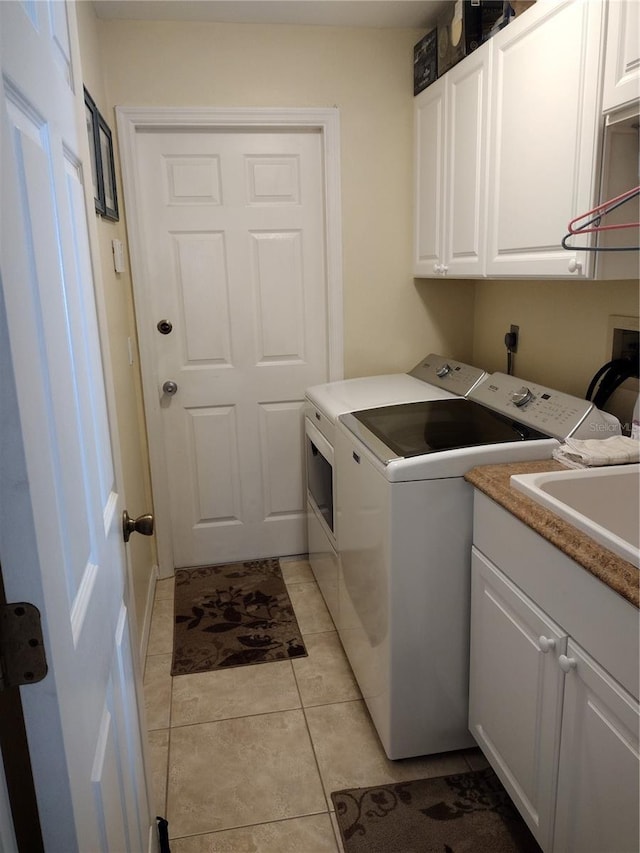 laundry area with cabinets, washer and clothes dryer, and light tile patterned flooring