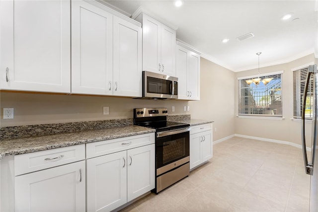 kitchen with white cabinets, appliances with stainless steel finishes, ornamental molding, and a notable chandelier