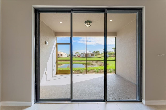 doorway to outside with light tile patterned flooring and a water view