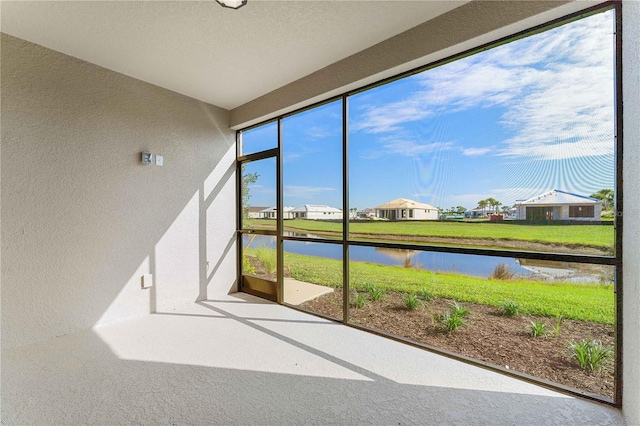 unfurnished sunroom with a water view