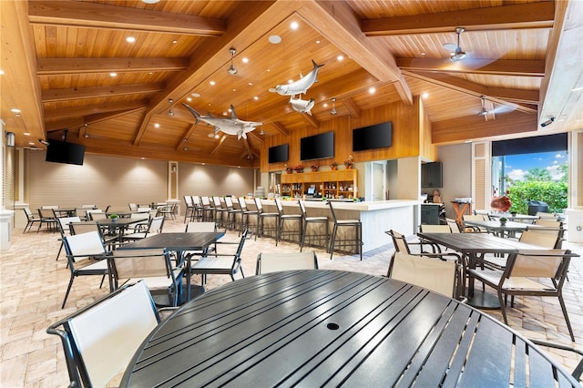 dining space with ceiling fan, beamed ceiling, wood ceiling, and high vaulted ceiling