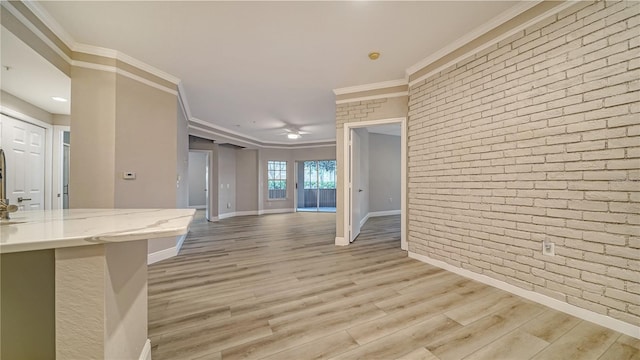 unfurnished living room with light hardwood / wood-style floors, brick wall, and ornamental molding