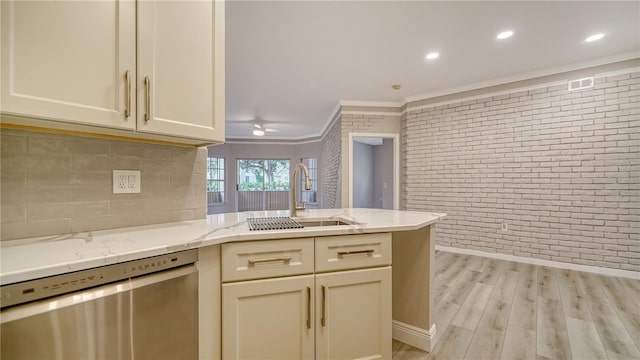 kitchen with light stone countertops, brick wall, sink, light wood-type flooring, and stainless steel dishwasher