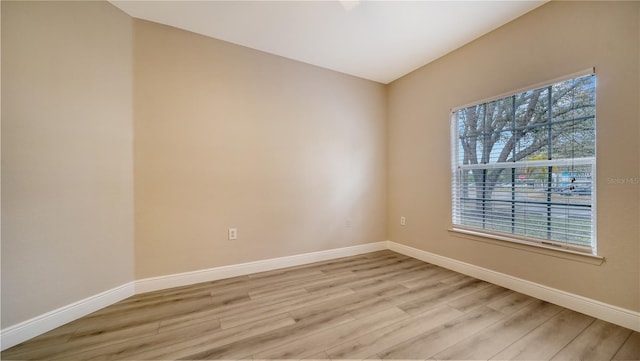 spare room with light hardwood / wood-style flooring and a wealth of natural light