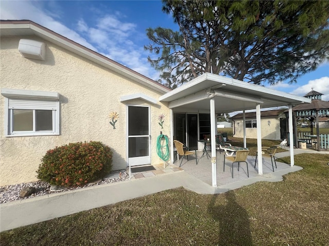 rear view of house featuring a yard and a patio