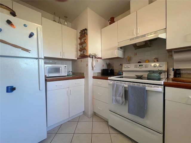 kitchen featuring white cabinetry, light tile patterned flooring, white appliances, and backsplash