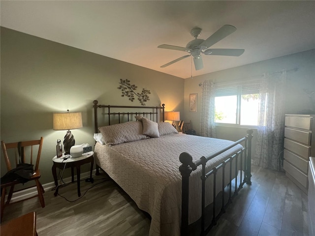 bedroom with dark hardwood / wood-style flooring and ceiling fan