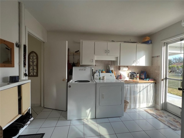 clothes washing area featuring separate washer and dryer, a wealth of natural light, and light tile patterned floors