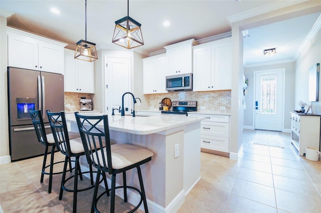 kitchen featuring white cabinetry, stainless steel appliances, tasteful backsplash, a kitchen island with sink, and sink