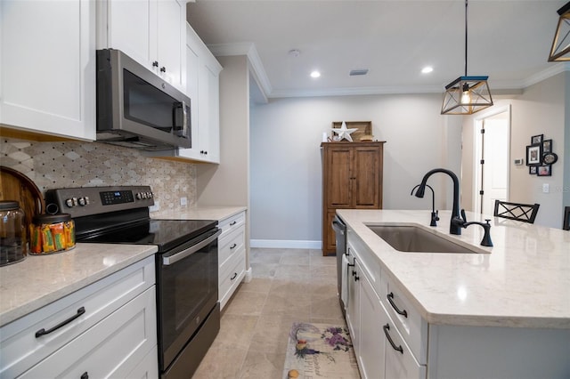 kitchen featuring pendant lighting, appliances with stainless steel finishes, white cabinetry, sink, and a center island with sink