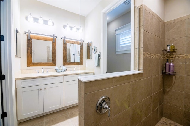 bathroom featuring vanity, tile patterned flooring, and tiled shower