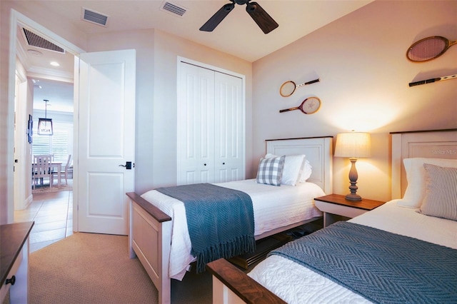 tiled bedroom featuring ceiling fan and a closet