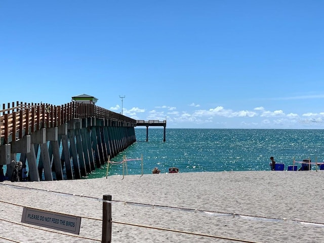 surrounding community with a water view and a view of the beach