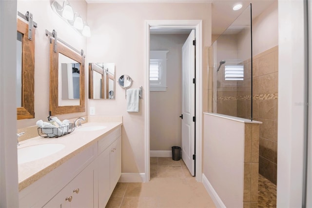 bathroom with tile patterned flooring, a tile shower, and vanity