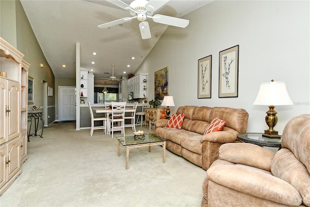 living room with ceiling fan, high vaulted ceiling, and light colored carpet