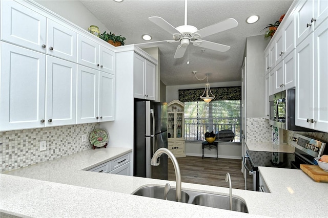 kitchen featuring backsplash, white cabinetry, sink, and appliances with stainless steel finishes