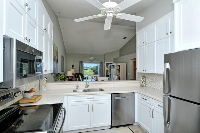 kitchen with white cabinets, appliances with stainless steel finishes, and lofted ceiling