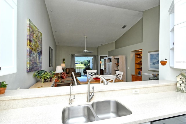 kitchen with vaulted ceiling, ceiling fan, sink, dishwasher, and white cabinets