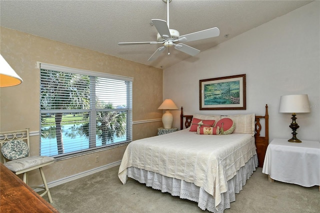 carpeted bedroom featuring ceiling fan, a textured ceiling, and vaulted ceiling