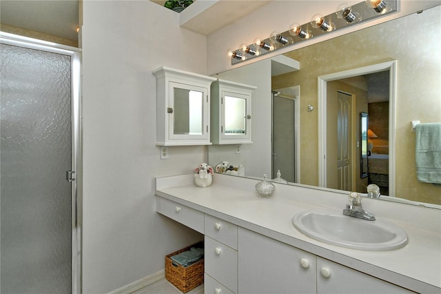 bathroom featuring a shower with door and vanity